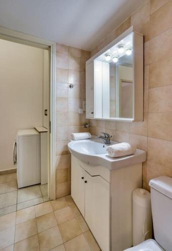 a bathroom with a sink and a toilet and a mirror at Rena's Guesthouse, by Comfortbnb in Sitia