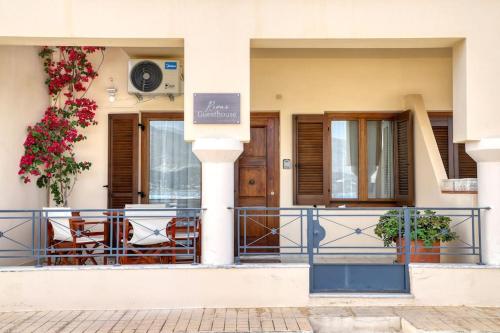 a building with a balcony with chairs and flowers at Rena's Guesthouse, by Comfortbnb in Sitia