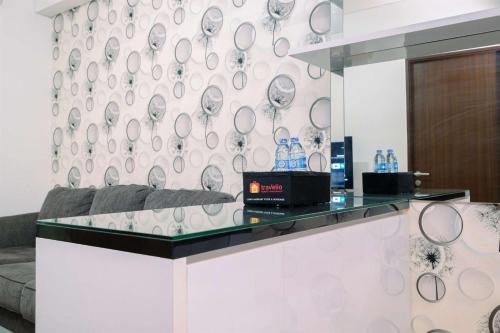 a lobby with a counter with a wall of mirrors at Good Deal and Relaxing 2BR Transpark Cibubur Apartment By Travelio in Depok