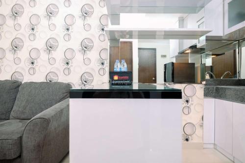 a living room with a couch and a counter top at Good Deal and Relaxing 2BR Transpark Cibubur Apartment By Travelio in Depok