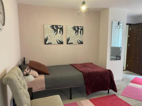 a bedroom with a bed and two paintings on the wall at Ferienwohnungen Clara in Arnstadt