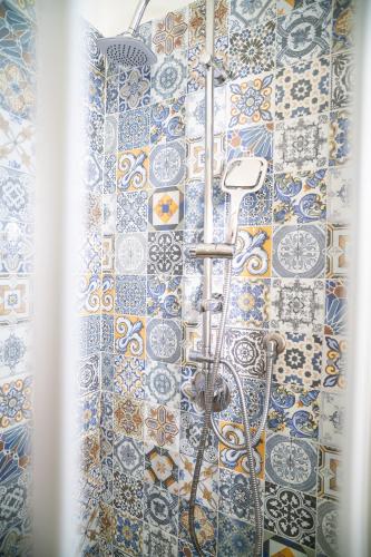 un bagno con doccia con piastrelle blu e bianche di B&B La Melagrana a Paestum