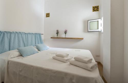 a bedroom with a bed with towels on it at Alghero Ciutat in Alghero