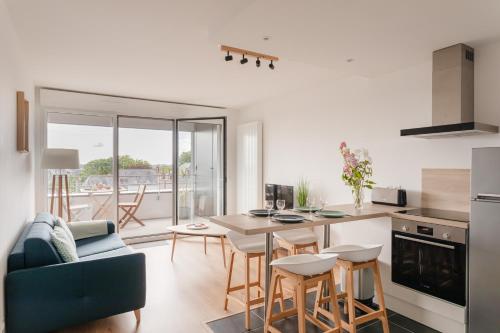 une cuisine et un salon avec une table et des chaises dans l'établissement Men Du - Appt 4p à 800 metres de la plage, à Dinard