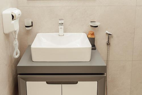 a bathroom with a white sink and a phone at Tskaltubo Apartments in Tskaltubo