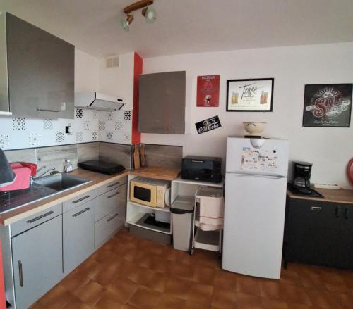 une petite cuisine avec un réfrigérateur et un évier dans l'établissement Studio Asphodèles bord de mer, au Cap d'Agde