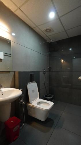 a bathroom with a toilet and a sink at Hotel Hive Inn - Kozhikode in Kozhikode