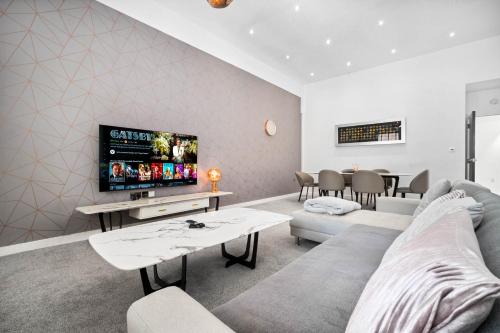 a living room with a couch and a tv at Apartment - Secure Parking - Gated Development - Near JQ & Birmingham City Centre - Top Rated - Flower Wall - 12SH in Birmingham