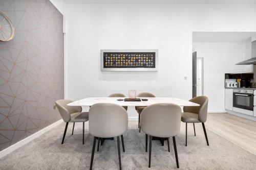 a dining room with a white table and chairs at Apartment - Secure Parking - Gated Development - Near JQ & Birmingham City Centre - Top Rated - Flower Wall - 12SH in Birmingham
