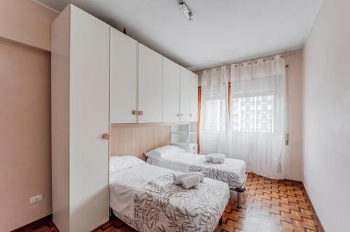 a bedroom with two beds and a window at Miranda - Apartament in Mestre with Balcony! in Marghera