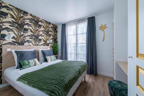 a bedroom with a bed with a green blanket at Jungle Duplex with pool 5 min Disneyland in Serris