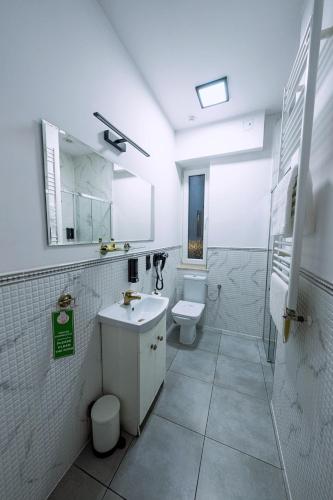 a bathroom with a sink and a toilet and a shower at Elegant Apartments in Poznań