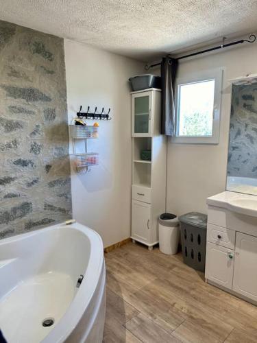 une salle de bain avec une baignoire blanche et un lavabo dans l'établissement Grande maison en Cévennes,montagne, lacs, rivières, à Concoules