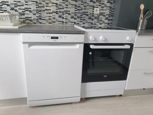 La cuisine est équipée d'une cuisinière et d'un four blanc. dans l'établissement B5 - Mont St Martin - RDC, à Mont-Saint-Martin