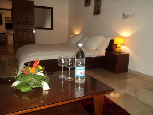 a bottle of water on a table with wine glasses at Residence Helios in Abidjan