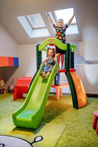 two children playing on a slide in a play room at Hotel Młyn Aqua Spa Biblioteka in Elblag