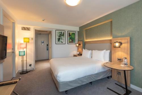 a hotel room with a large bed and a television at Holiday Inn Brentwood by IHG in Brentwood