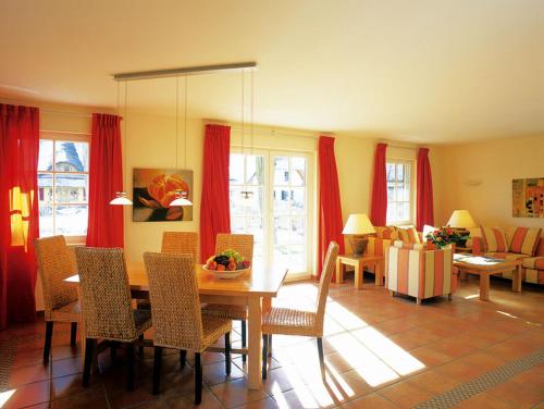 a living room with a table and chairs and a couch at Ferienhäuser Fischland in Dierhagen