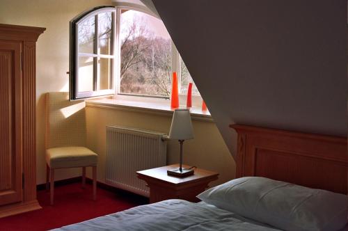 a bedroom with a bed and a window at Ferienhäuser Fischland in Dierhagen