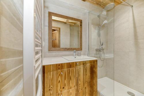 une salle de bain avec un lavabo, un miroir et une baignoire dans l'établissement Homency - Résidence le Président 214, à L'Alpe-d'Huez