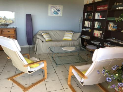 un salon avec deux chaises et un canapé dans l'établissement Hippocampe, à Anglet