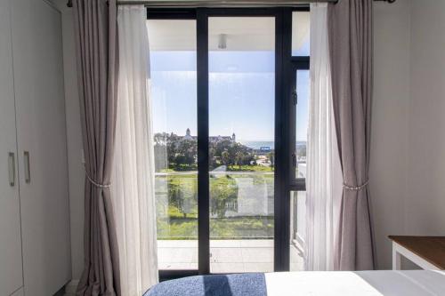 a bedroom with a large window with a view at Bella Mare 13 on Boardwalk in Gqeberha