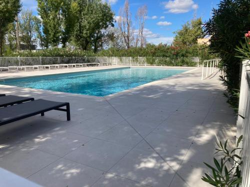 - une piscine avec un banc à côté dans l'établissement T2 cosy et au calme, à Saint-Rémy-de-Provence