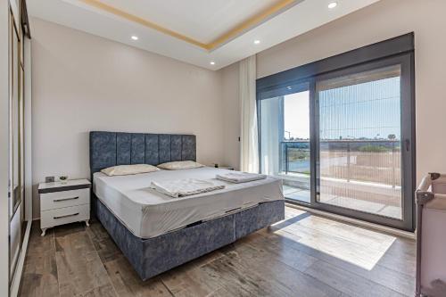 a bedroom with a bed and a large window at Villa Tosun in Belek