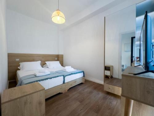 a bedroom with a large bed and a mirror at Saint 40 Suites Premium Flat in Sarandë