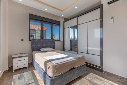 a bedroom with a large bed and large windows at Villa Tosun in Belek