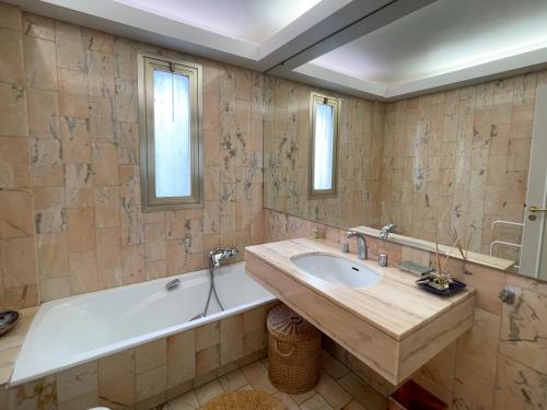 une salle de bain avec une baignoire et un lavabo dans l'établissement 2 bedroom apartment with parking 3 mins from La Croisette beach, à Cannes