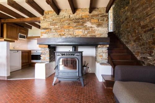 d'un salon avec une cheminée et un mur en pierre. dans l'établissement Village de gîtes de Barre-des-Cévennes, à Barre-des-Cévennes