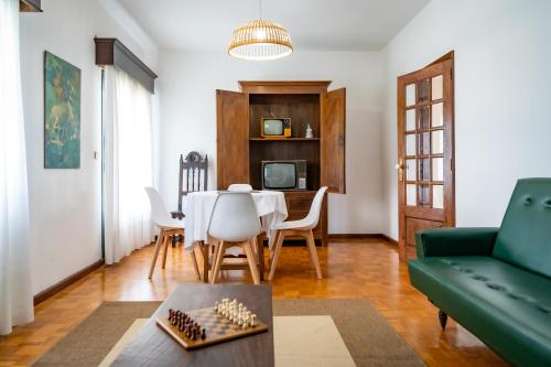 a living room with a table and a green couch at Casa da Professora Ponte de Lima in Refoios do Lima