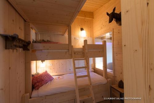 a bedroom with two bunk beds in a log cabin at Homency - Résidence Ménandière E6 in L'Alpe-d'Huez