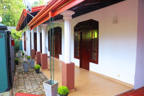 a white building with red doors and potted plants at Bella Vista Villa in Seeduwa