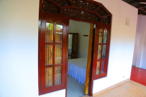 a room with a bed and a door with stained glass at Bella Vista Villa in Seeduwa
