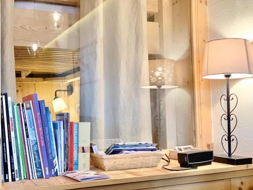 a shelf with two lamps and books on it at Homency - Résidence Ménandière E6 in L'Alpe-d'Huez