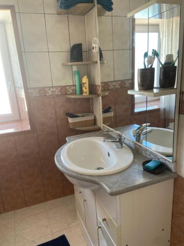 une salle de bain avec un lavabo et un miroir dans l'établissement Le grand logis, à Les Sables-dʼOlonne