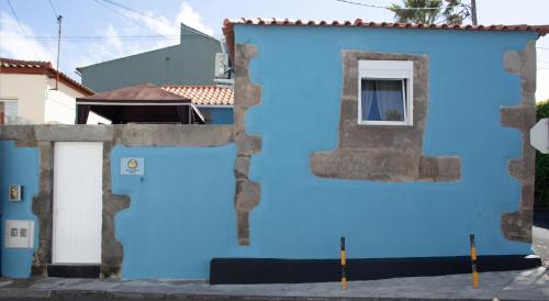 a blue building with a window and a door at Açores à Mesa House Casa do Terreiro in Terra Chã