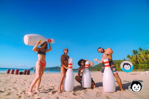 a group of people on the beach with surfboards at Mad Monkey Hostel Nacpan Beach in El Nido