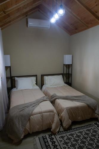 two beds sitting next to each other in a room at Açores à Mesa House Casa do Terreiro in Terra Chã