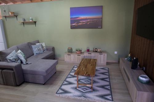 a living room with a couch and a table at Açores à Mesa House Casa do Terreiro in Terra Chã