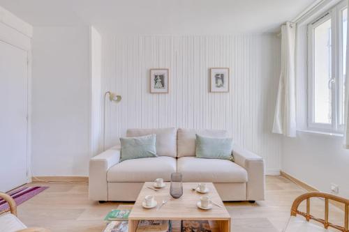 un salon avec un canapé blanc et une table basse dans l'établissement Appartement Alegria - Welkeys, à Bandol