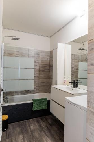 une salle de bain blanche avec une baignoire et un lavabo dans l'établissement Eden Lac et Montagnes, à Saint-Jorioz