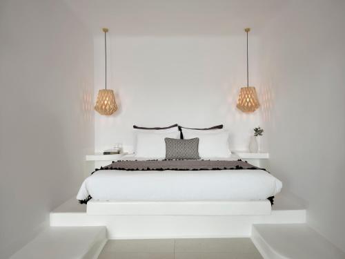 a white bedroom with a white bed with two lights at Mykonos No5 Luxury Suites & Villas in Ornos
