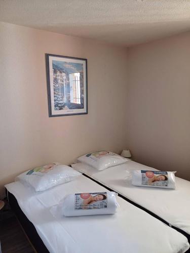 - 2 lits jumeaux dans une chambre avec une photo sur le mur dans l'établissement APPT 2 Pièces 32m2 avec Loggia vitrée REF 4001, à Le Castellas