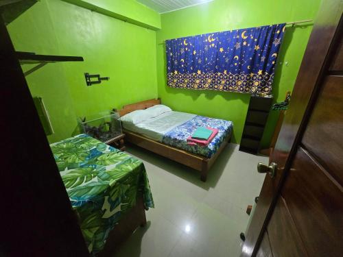 a small room with two beds and a window at ZevZev Transient House in Banaue