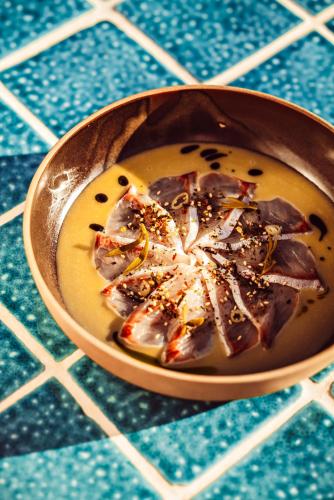 a bowl of soup on a blue and white table at Petunia Ibiza, a Beaumier hotel in Cala Vadella