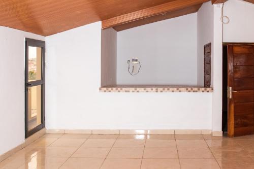 a room with a white wall with a window at Hotel Résidence Essiéniguet in Abidjan
