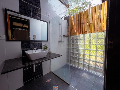 a bathroom with a sink and a mirror and a window at The Dusun in Seremban